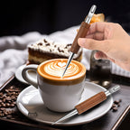 Rosewood latte art needle resting on a saucer beside a coffee cup