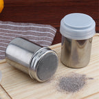 Stainless-steel dusting shaker dusting cocoa on a board