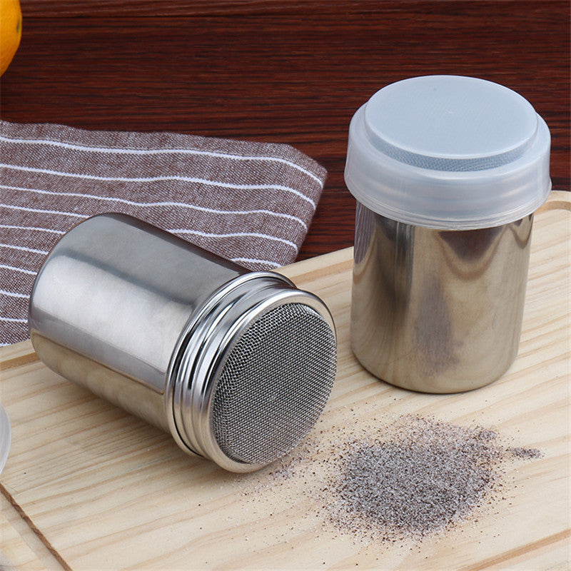 Stainless-steel dusting shaker dusting cocoa on a board