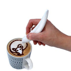 Electric latte art pen creating a design on cappuccino foam