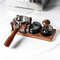 TrueShih Walnut Tamping Station holding an espresso portafilter, tamper and puck screen on a marble counter