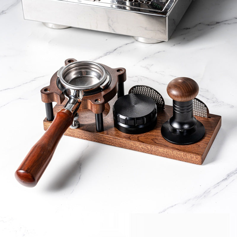 TrueShih Walnut Tamping Station holding an espresso portafilter, tamper and puck screen on a marble counter